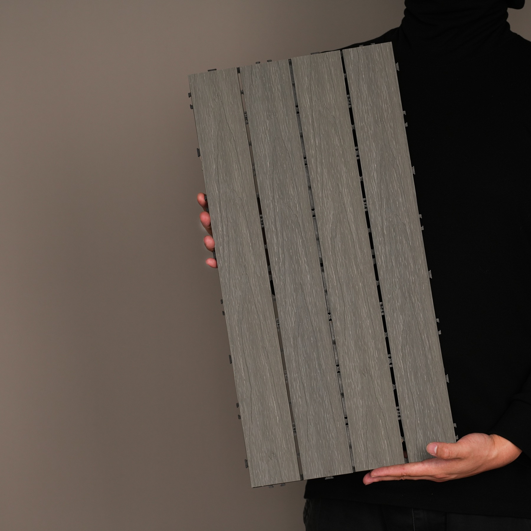 AN JU JIE modular quick-install decking tile held against a dark studio background
