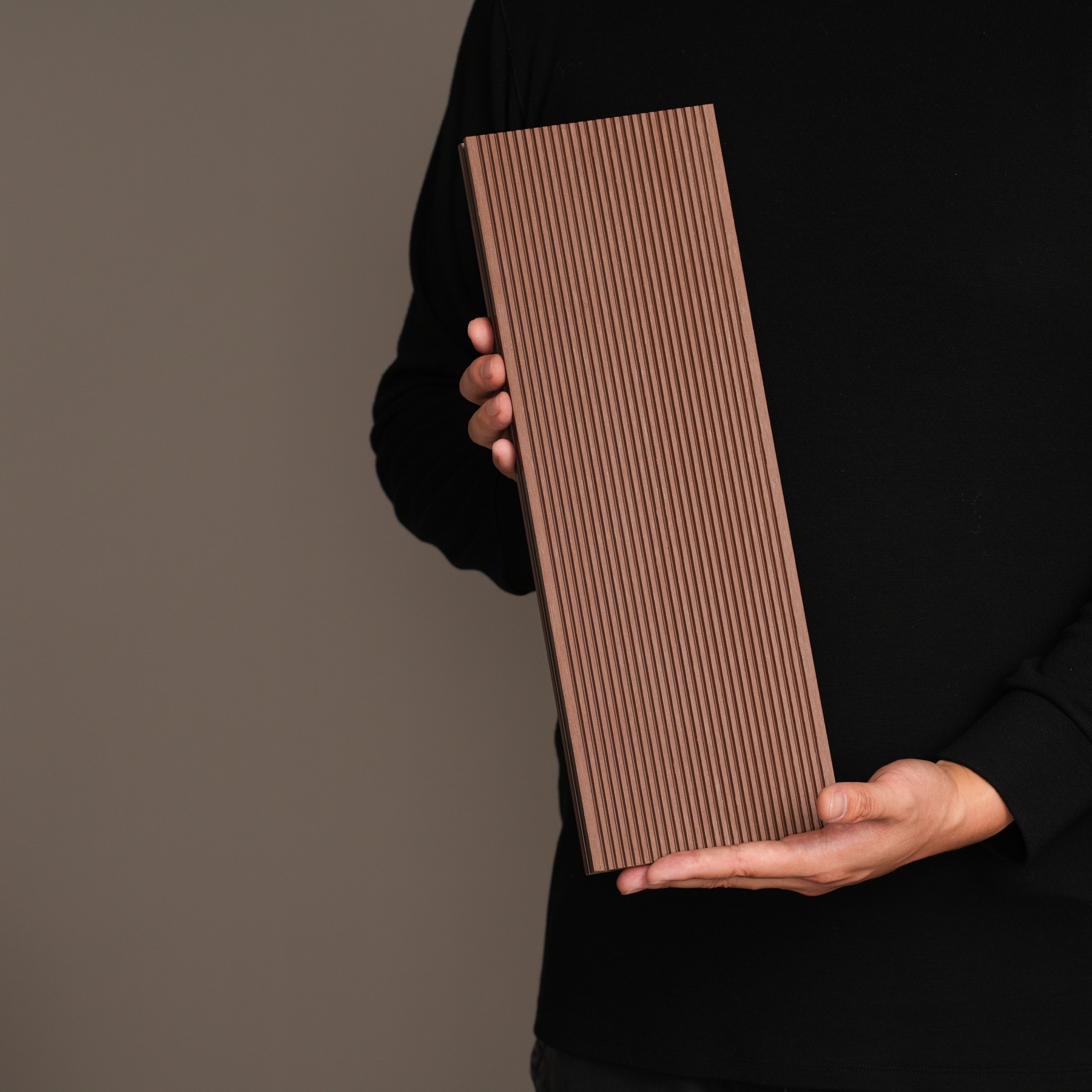 AN JU JIE aluminum decking sample held against a dark studio background