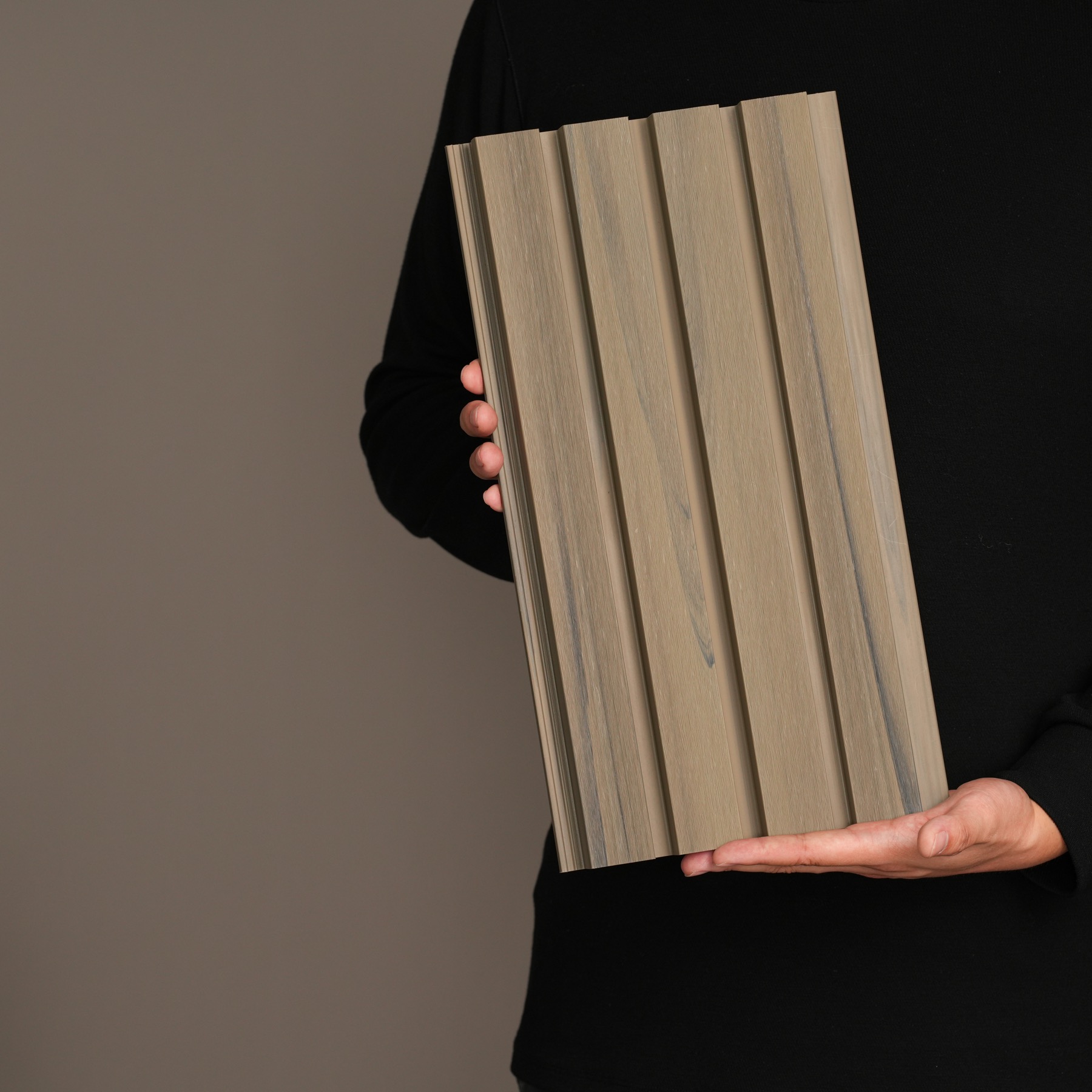 AN JU JIE fluted wall cladding sample held against a dark studio background